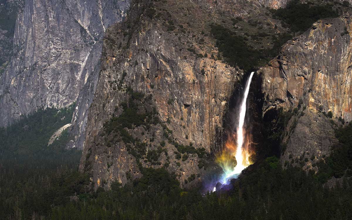 rainbow colors form at the base of bridalveil falls in yosemite national park