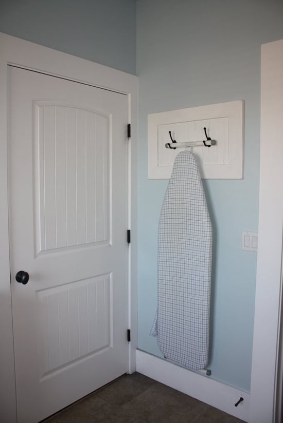 use two coat hangers to hang your ironing board.
