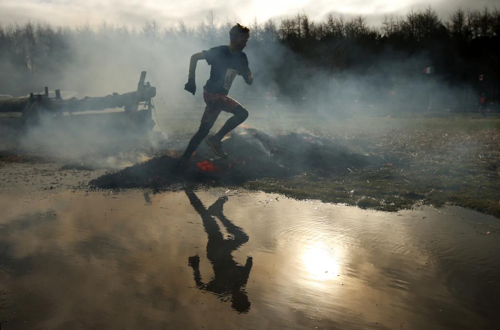 a competitors run through smoke and flames during the tough guy event in perton, central england