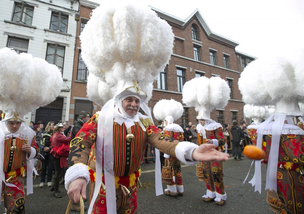 gille of binche throws an orange while taking part in the parade during the carnival event in binche