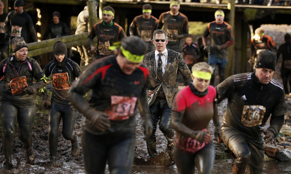 competitors run through mud during the tough guy event in perton, central england