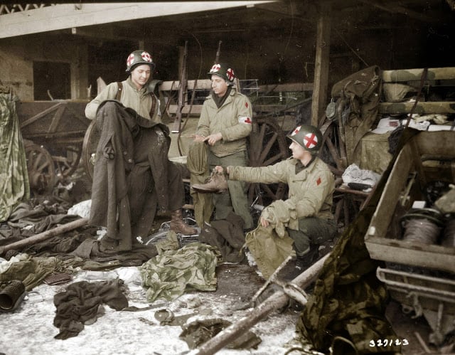 medics of the us. 5th infantry division examining gi clothing found with german-captured equipment after the liberation of the area, near diekirch in luxembourg on the 20th of january 1945. (source - sc-327129 signal corps photo eto-hq-45-9223 -horton. colorized by joey van meesen from the netherlands)