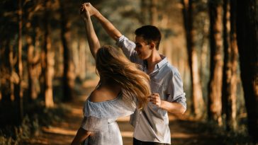 man and woman dancing at center of trees