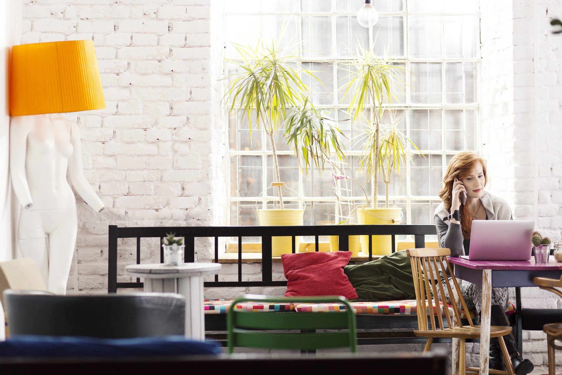 Copywriter woman using notebook and smartphone working in loft studio