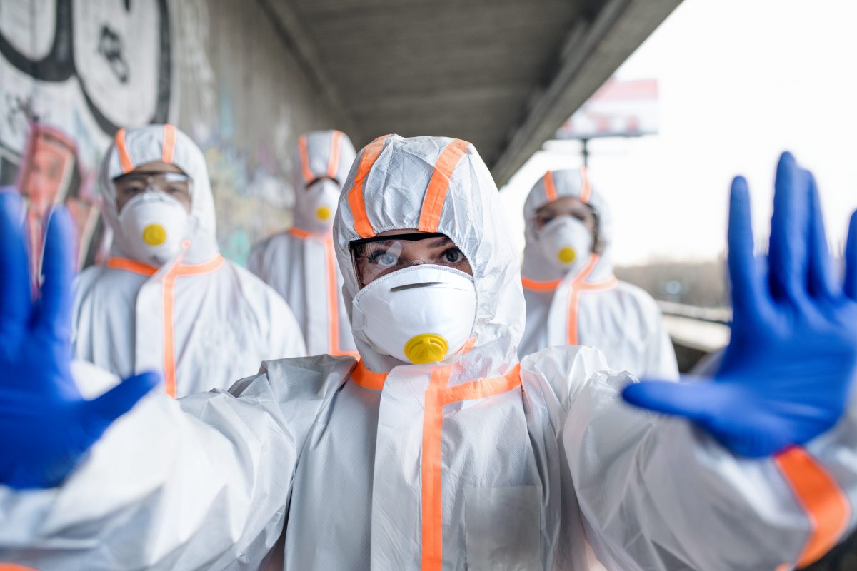 people with protective suits and mask respirators outdoors, coronavirus concept.