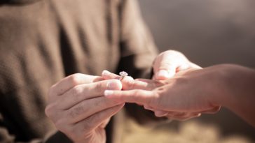 person holding silver diamond ring