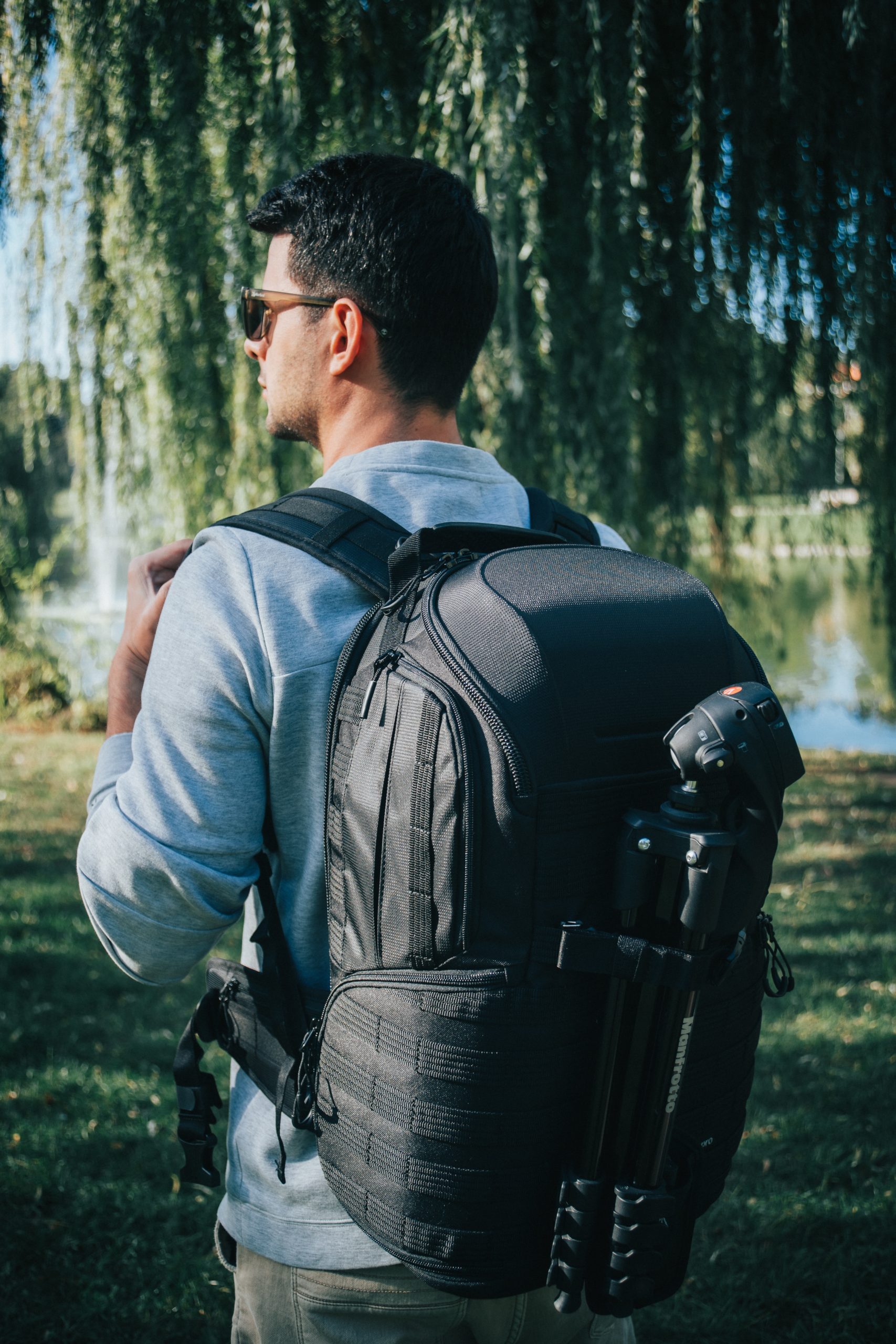 selective focus photography of man carrying backpack while standing near outdoor during daytime