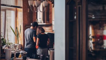 man and woman standing in front of gas range