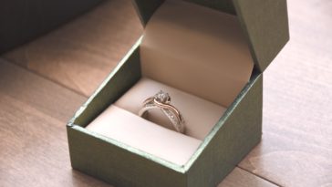 silver-colored ring with gemstone in a box