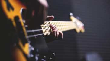 closeup photo of person playing guitar