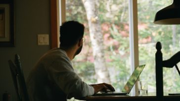 man in gray hoodie using laptop computer