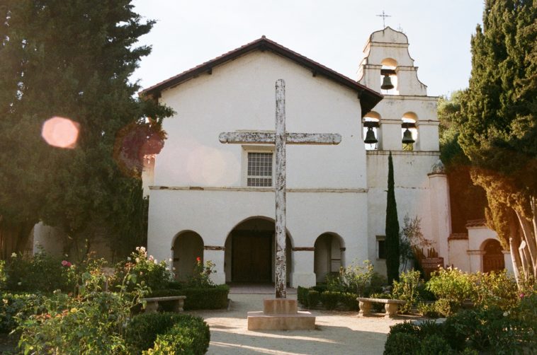 a garden in front of mission san juan bautista