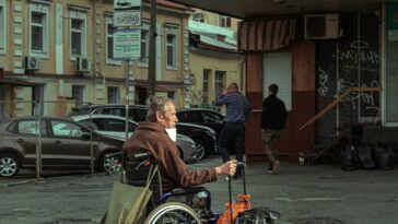 man in black jacket riding on bicycle during daytime