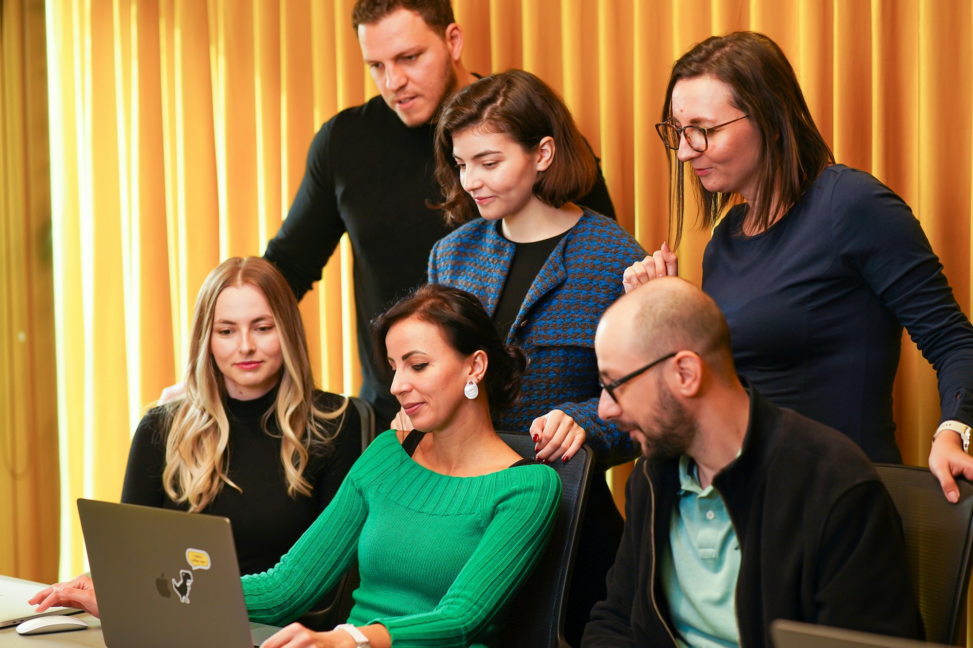 Selecting the Best Proposal Software Options for Small Businesses a group of people sitting around a laptop computer