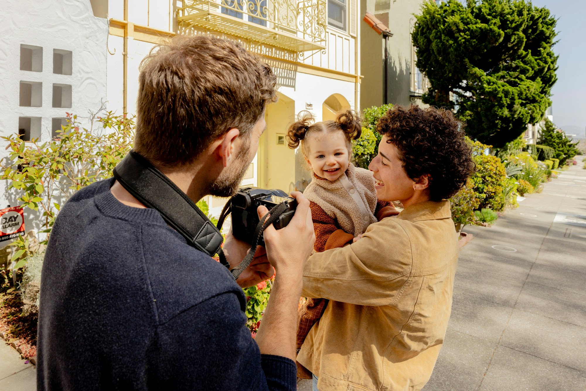 Lifestyle Photography in Sydney: Memorable Family Photos Without Breaking the Bank a man taking a picture of a woman holding a baby