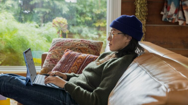 a person sitting at a table using a laptop