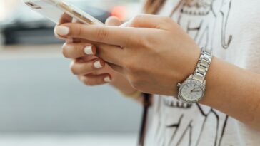woman holding iphone during daytime