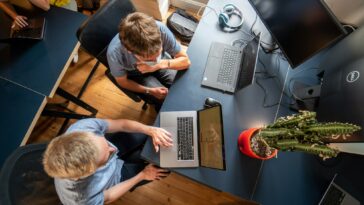 man in gray long sleeve shirt using macbook pro