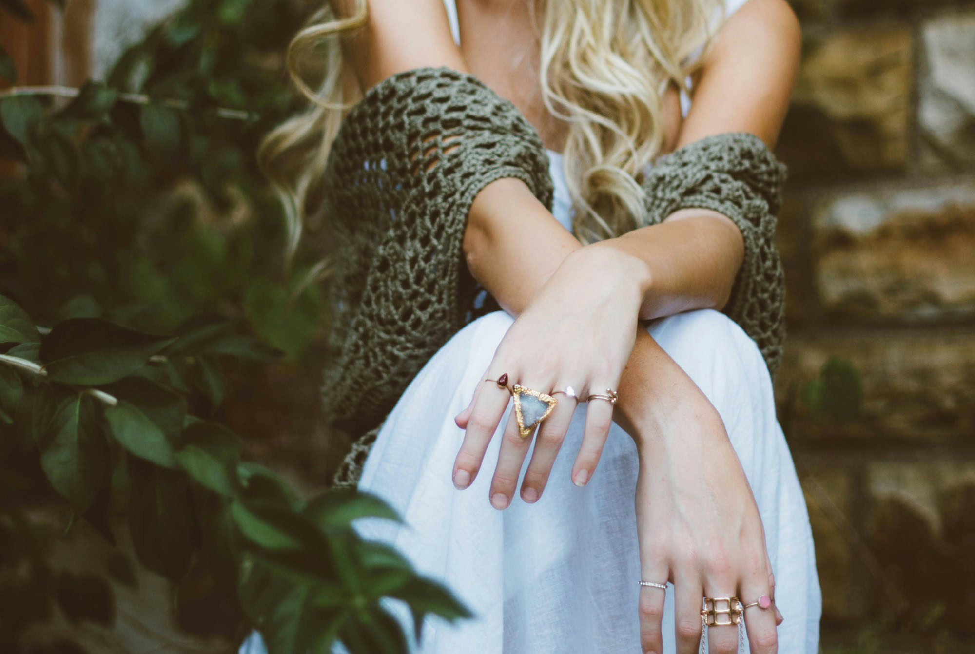 Travel-Inspired Jewellery: Destinations That Influence Ring Style woman sitting beside plant and concrete wall