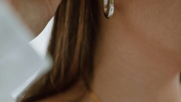 woman in white shirt wearing gold necklace