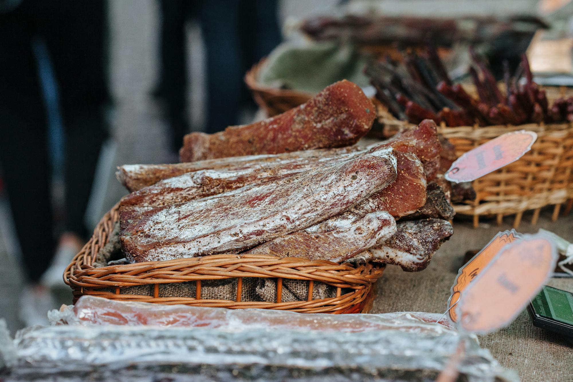 10 Best Meat Preservation Methods: Traditional & Modern Techniques Explained a basket of seasoned and dried beef and pork at a rustic food market.